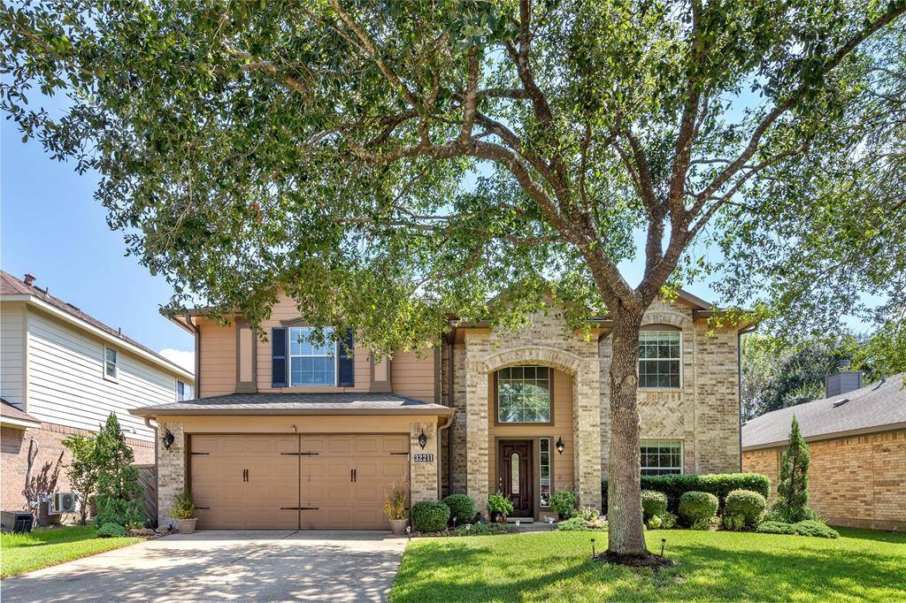 A manicured lawn shaded by a mature tree and beautiful landscaping are just the place for your to call home.