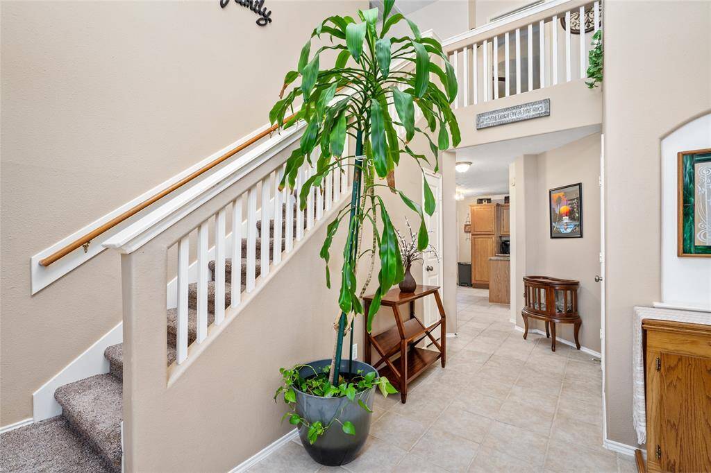 Another view of your entryway highlighting the staircase with wooden accents hinting at a cozy yet open interior layout.