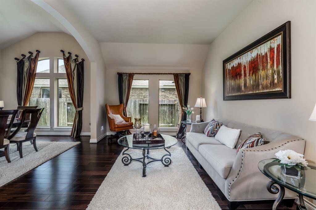 The den features two large windows that bring is tons of light, along with the engineered wood flooring.