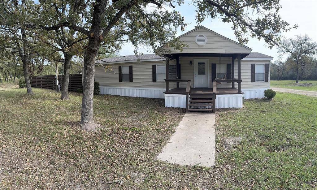 Front view of home, large shop building behind.