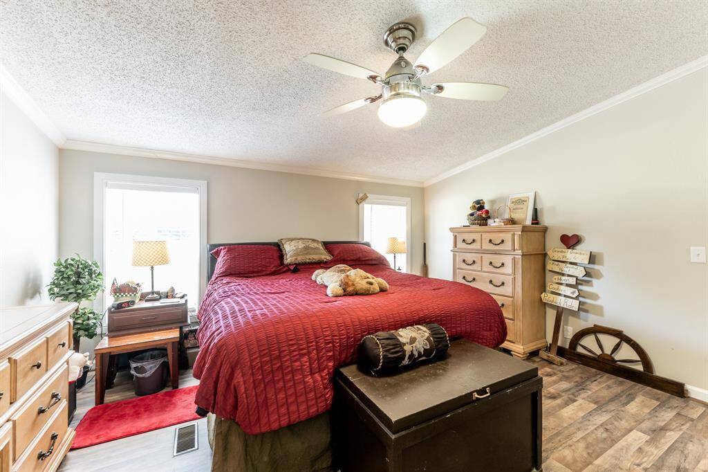 Spacious primary bedroom featuring a king-size bed and ample furniture, perfect for comfort and style.