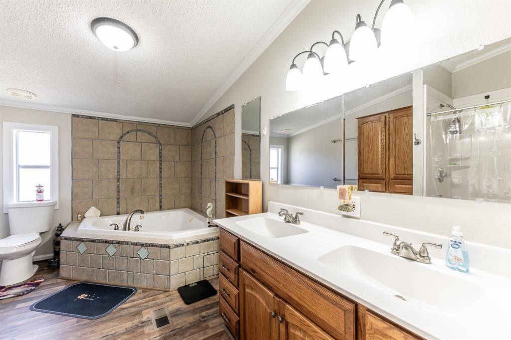 Luxurious primary bath featuring a garden tub, dual sinks, and a separate shower.