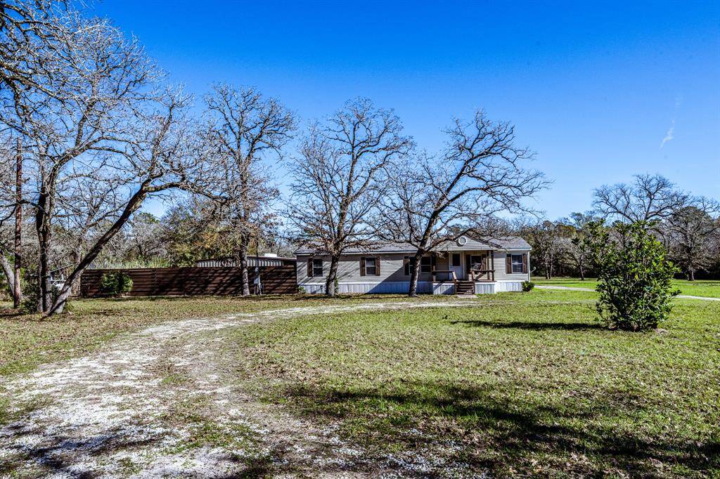 Charming country home surrounded by mature trees on a spacious lot. Features a welcoming front porch and a private driveway. Ideal for those seeking a tranquil, rural setting.