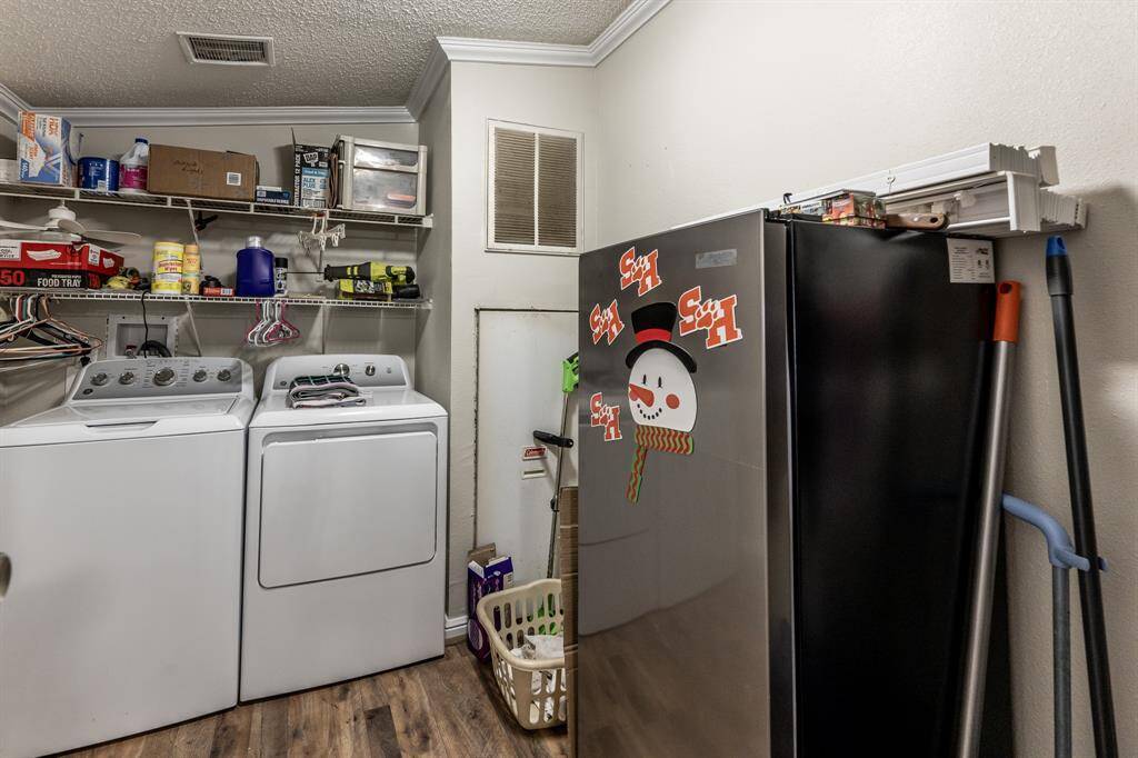 Spacious utility room with washer, dryer, and ample shelving for organized storage.