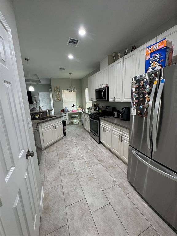 This room features a modern, open design with tiled flooring and recessed lighting.