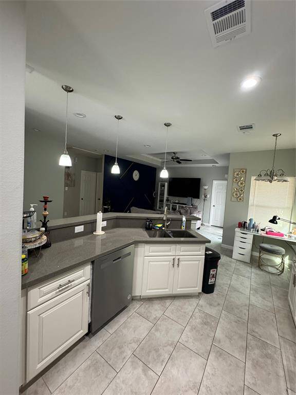 Experience modern elegance in this bright kitchen, featuring sleek white cabinets, stainless steel appliances, and tiled flooring. Enjoy ample counter space and stylish overhead lighting in a spacious, functional layout.