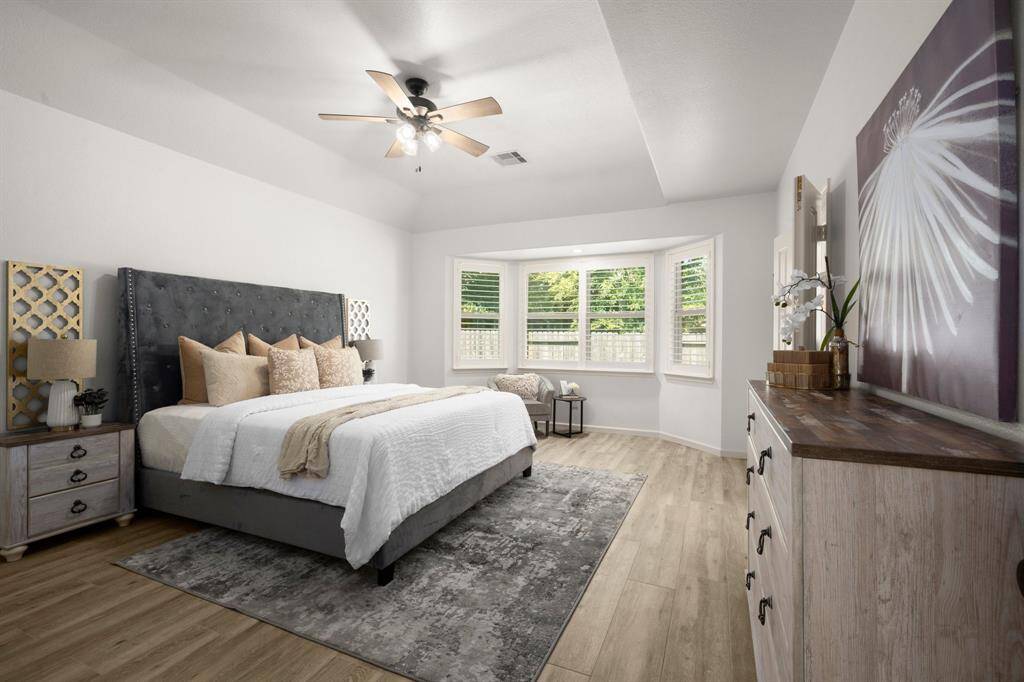 The spacious primary suite offers a tranquil retreat with soft natural light streaming through the elegant bay windows.