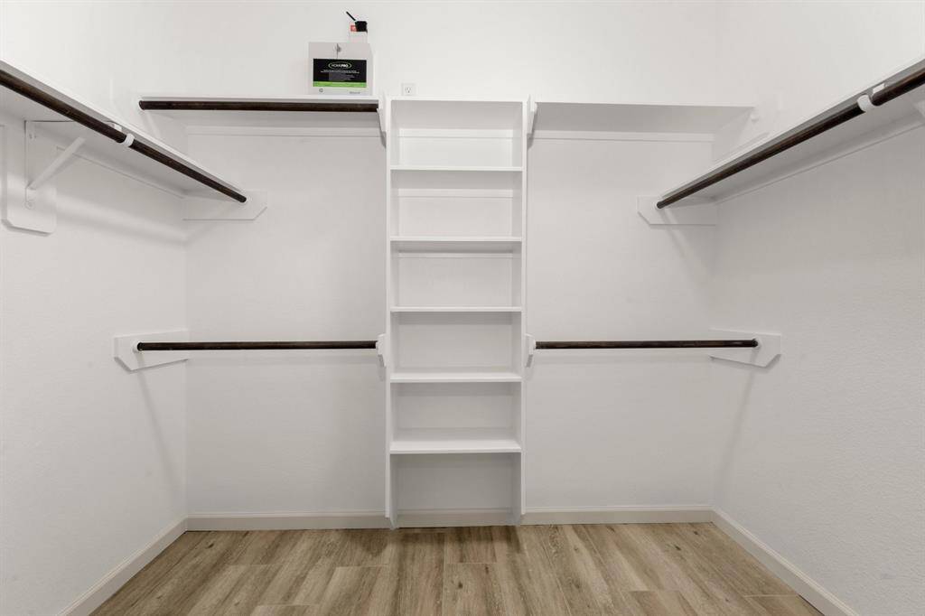Generous walk-in closet with custom shelving and abundant hanging space
