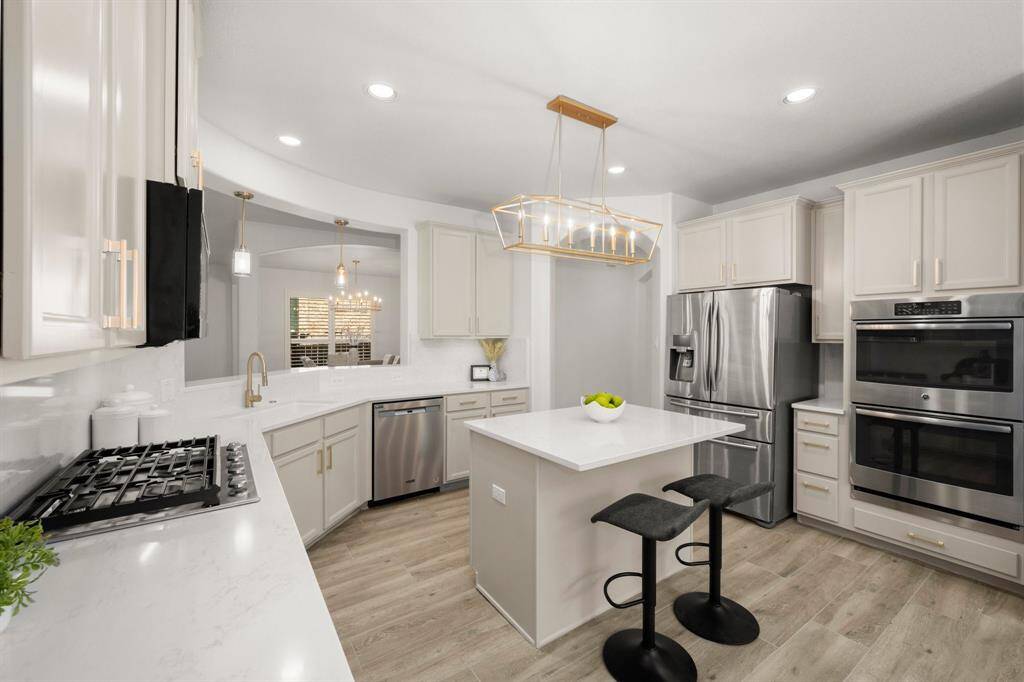 Gold hardware and modern pendant lighting add a touch of luxury to this bright and open space.