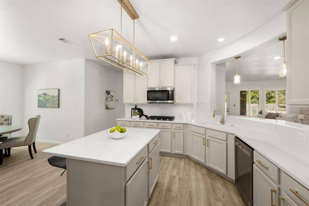 This open-concept kitchen seamlessly connects to the dining and living areas, creating a perfect flow for family gatherings or entertaining guests.