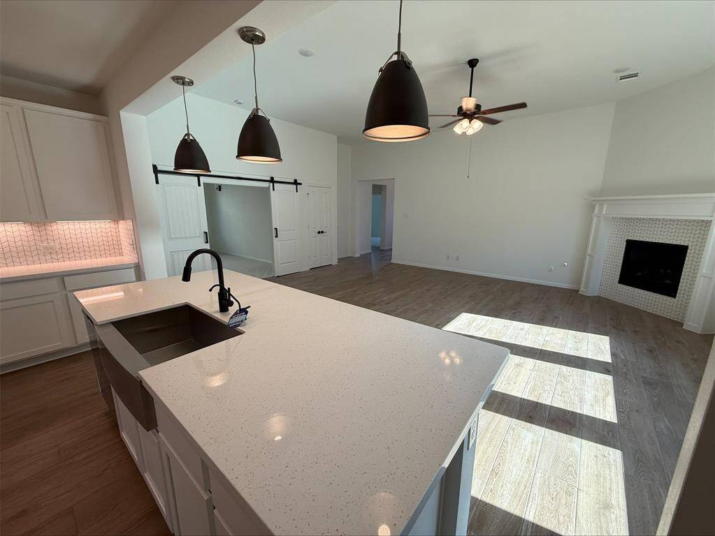 Kitchen island overlooks great room with cozy fireplace