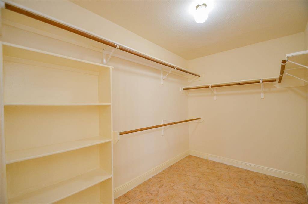 This spacious Primary bedroom walk-in closet on second floor features ample shelving and hanging rods, perfect for organized storage and easy access to your wardrobe.