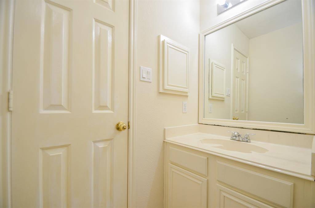 This is a second full bathroom on the second floor with a single sink vanity, ample counter space, and a large mirror. The light-colored cabinetry and neutral walls create a bright, clean atmosphere.