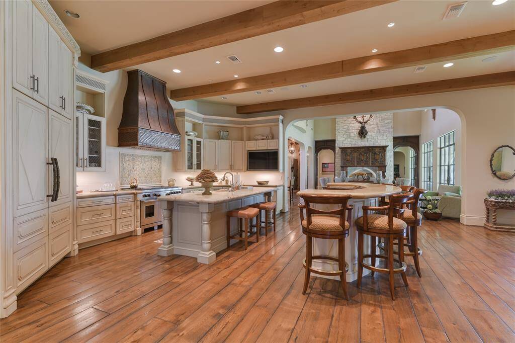 Shown here is the KITCHEN and two CENTER ISLANDS - wide planked hardwood flooring, 12 foot ceiling with exposed wood beams, recessed lighting, wood cabinets/drawers, stone counter-tops with decorative stone backsplash, top of the line appliances!
