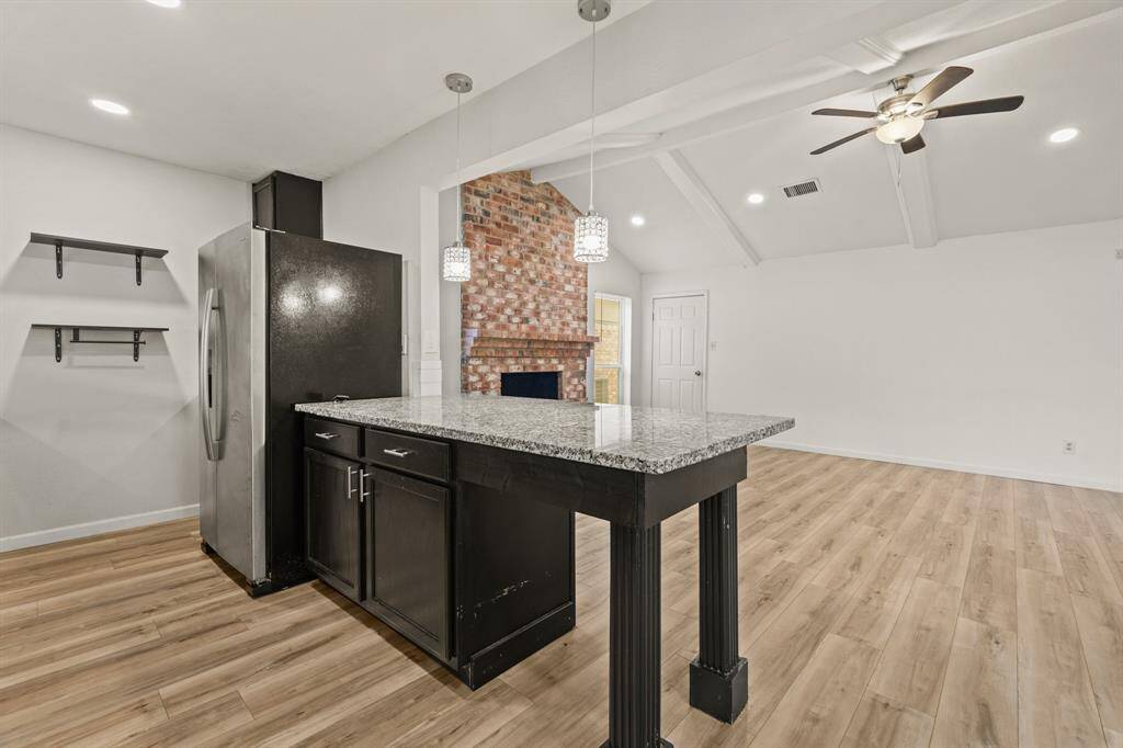 The focal point is a sleek breakfast bar thatnot only provides additional counterspace but also serves as a casualgathering spot.