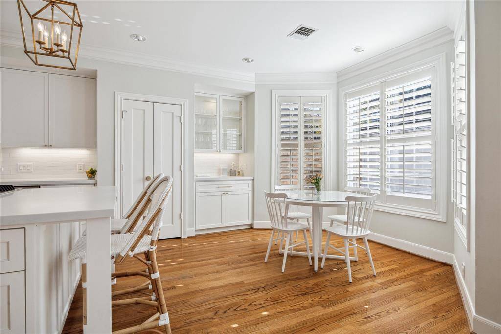 Breakfast area and pantry with sunlight streaming through shutters.