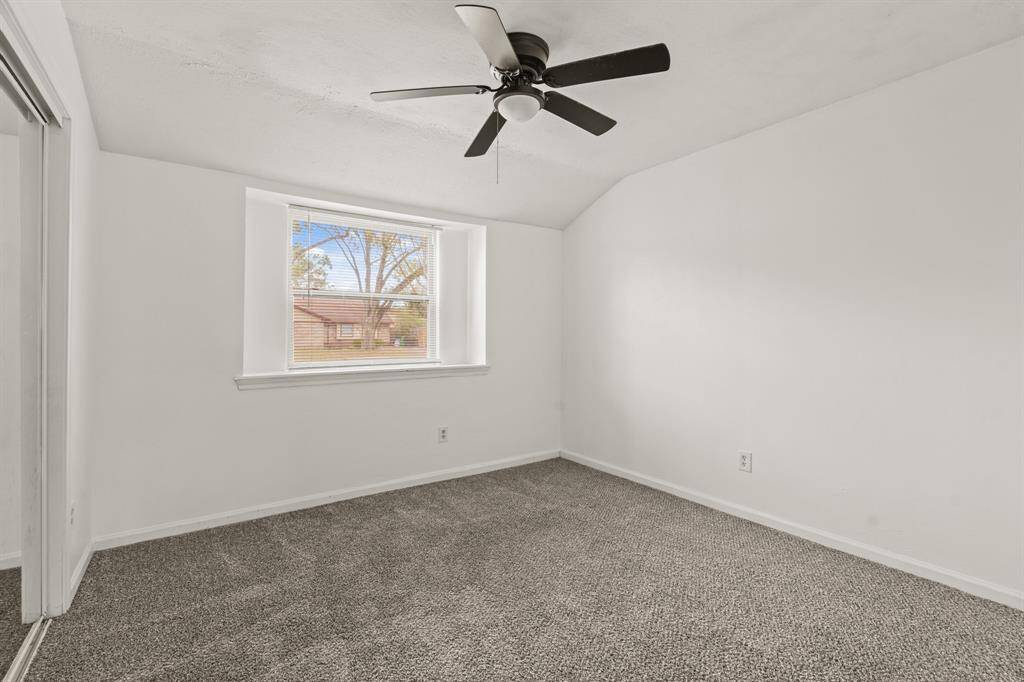 Secondary bedroom features awindow and plush carpet.