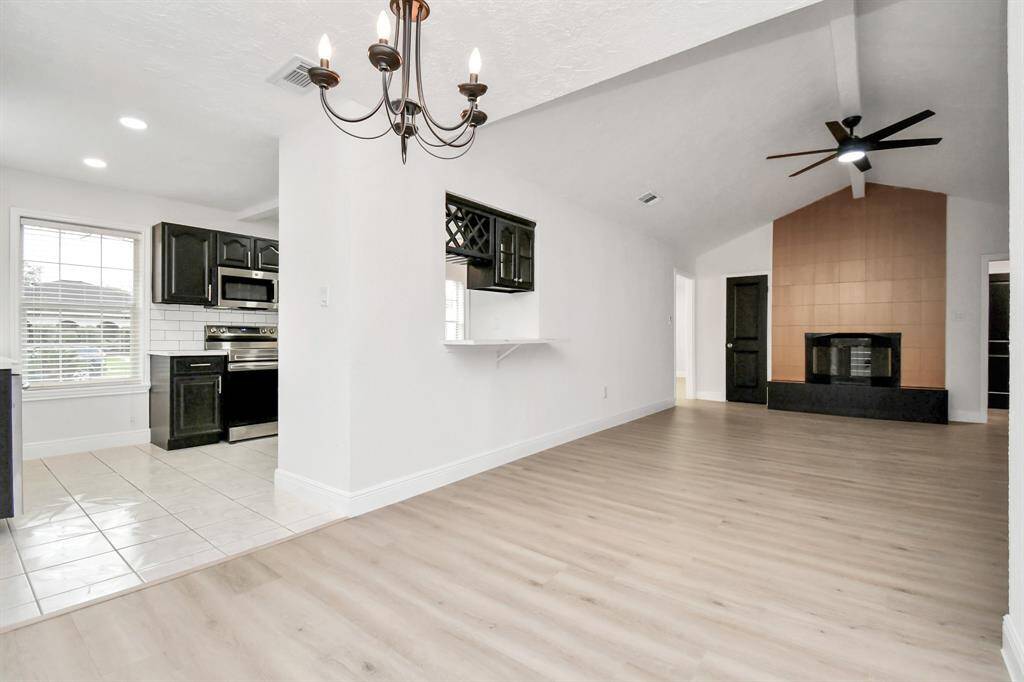 Spacious Living Area with Gorgeous Fire Place, Featuring a Glimpse into the Kitchen