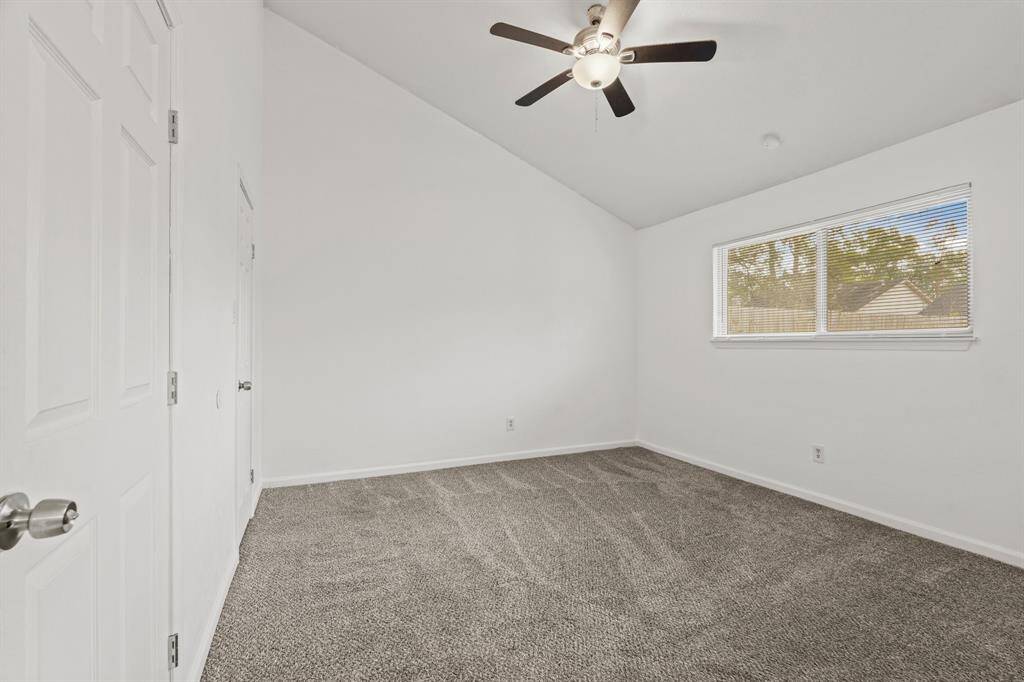 Third bedroom features awindow and plush carpet.