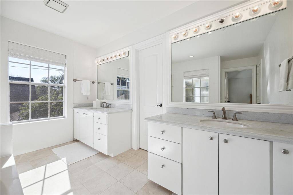Primary bath with double sinks and walk-in closet.