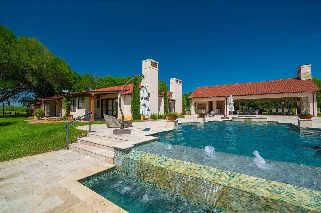 How relaxing is the infinity edge, spa, four water features and bubblers of the BACKYARD heated Pool! Seen here is the 3 bedroom Guest House with the outdoor Kitchen and Dining areas. Not seen to the right of the covered Dining is the Main House. Notice the numerous seating areas, both open and covered, afforded in the complex's carefully planned design.