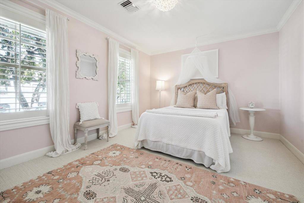 Darling secondary bedroom with chandelier and view onto shady front yard.