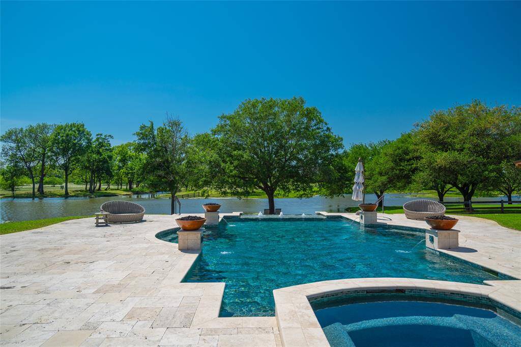 Another view of the BACKYARD POOL looking outward through the majestic trees to the lake beyond. What a great spot to relax and enjoy all the fabulous scenery and vistas!