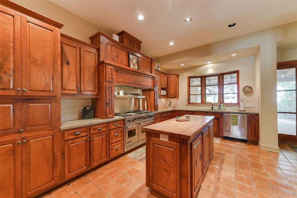 The KITCHEN (17 X 11) provides ample storage space with its stained wood cabinets/drawers with granite counters/stone backsplash. The center island features a butcher block counter. A wood framed bay window adds a charming coziness to the space while the stainless Viking appliances provide state of the art appliances for use by the cook!