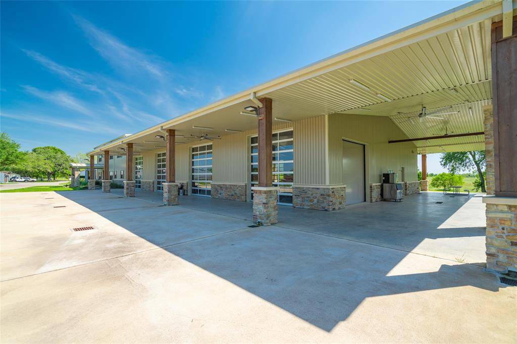 A closer view of the BARNDOMINIUM with its series of four car bays on one side of the building and two car bays on the other side. The main entry is seen at the far end of the building.