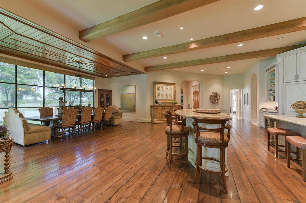 The well-planned DINING AREA with nearby KITCHEN and its two CENTER ISLANDS with SEATING - so created to encourage family and friends to gather casually amidst a spacious area with several seating arrangements. The DINING AREA (22 X 15) includes hardwood flooring, decorative wood planked ceiling/hanging light fixture, floor to ceiling windows overlooking outdoor landscape. The KITCHEN (27 X 28) includes two center islands with bar seating (stone counters, stained wood cabinets).