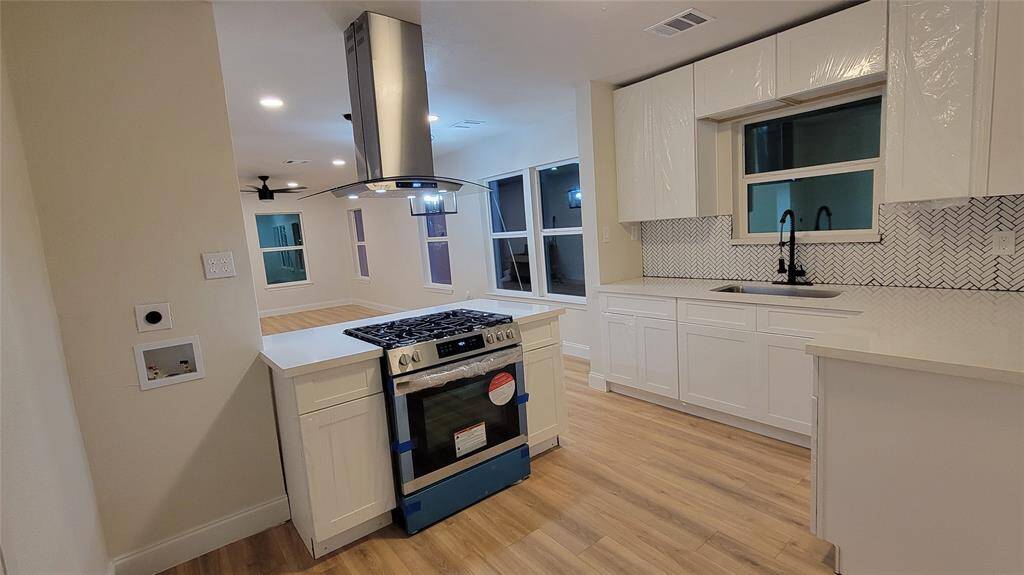 Another view of the kitchen with space for a stackable washer and dryer.
