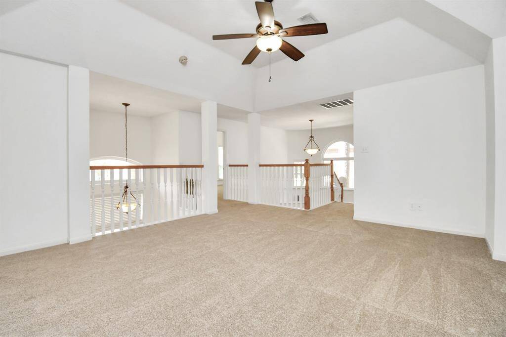 Gameroom with balcony overlooking foyer, an entrance to a bedroom and heading downstairs.