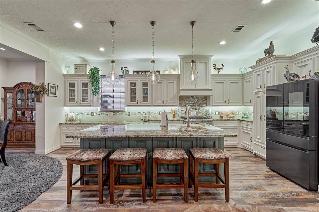 WOW! Just look at this gorgeous granite island! It is such a striking focal point against the white cabinetry. The pendant lighting illuminates the space and gives the air of sophistication.