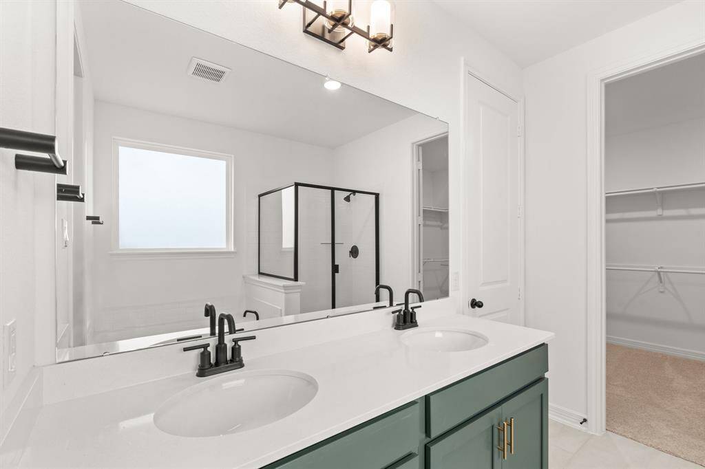 The en-suite bathroom offers a spa-like atmosphere with its elegant design, high end finishes, and tasteful lighting, creating a retreat within your own home.