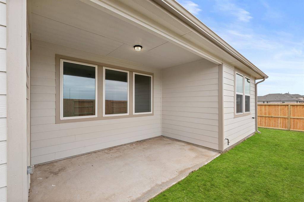 The covered patio is generously sized, providing ample space for various outdoor activities.