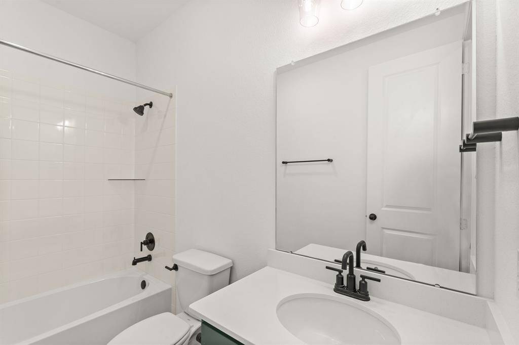 The secondary bath features tile flooring, white cabinetry and light countertops and a shower/tub combo. Perfect for accommodating any visiting family and friends.