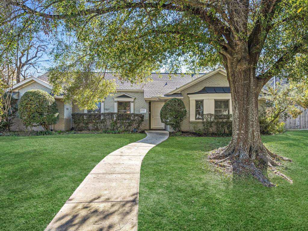 Charming single-story home with a brick exterior, featuring a well-maintained front yard and mature tree. A curved walkway leads to the inviting entrance, surrounded by lush greenery and shrubbery. Ideal for comfortable living in a serene setting.