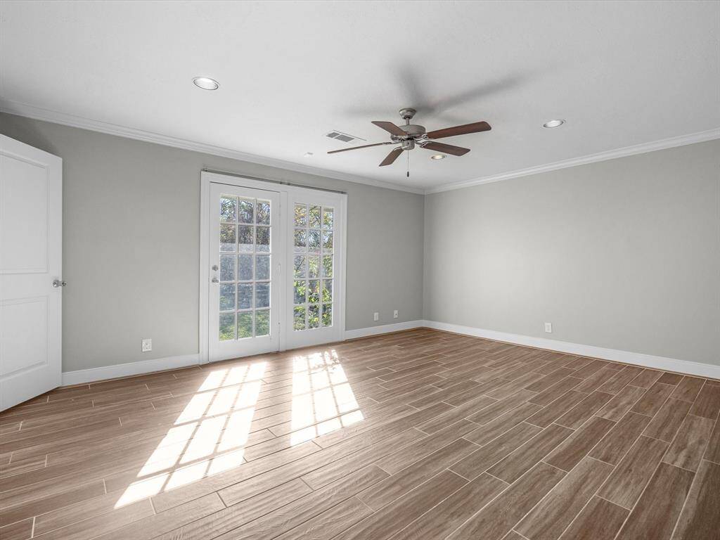 Experience serene backyard views through elegant French doors in the primary bedroom.