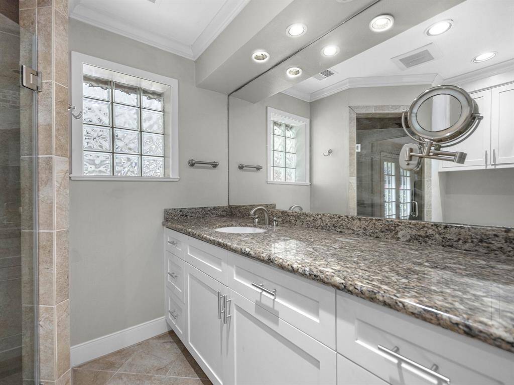 Charming single-story home with a brick exterior, featuring a well-maintained front yard and mature tree. A curved walkway leads to the inviting entrance, surrounded by lush greenery and shrubbery. Ideal for comfortable living in a serene setting.