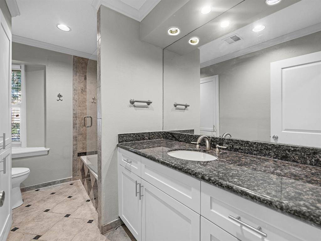 Charming single-story home with a brick exterior, featuring a well-maintained front yard and mature tree. A curved walkway leads to the inviting entrance, surrounded by lush greenery and shrubbery. Ideal for comfortable living in a serene setting.
