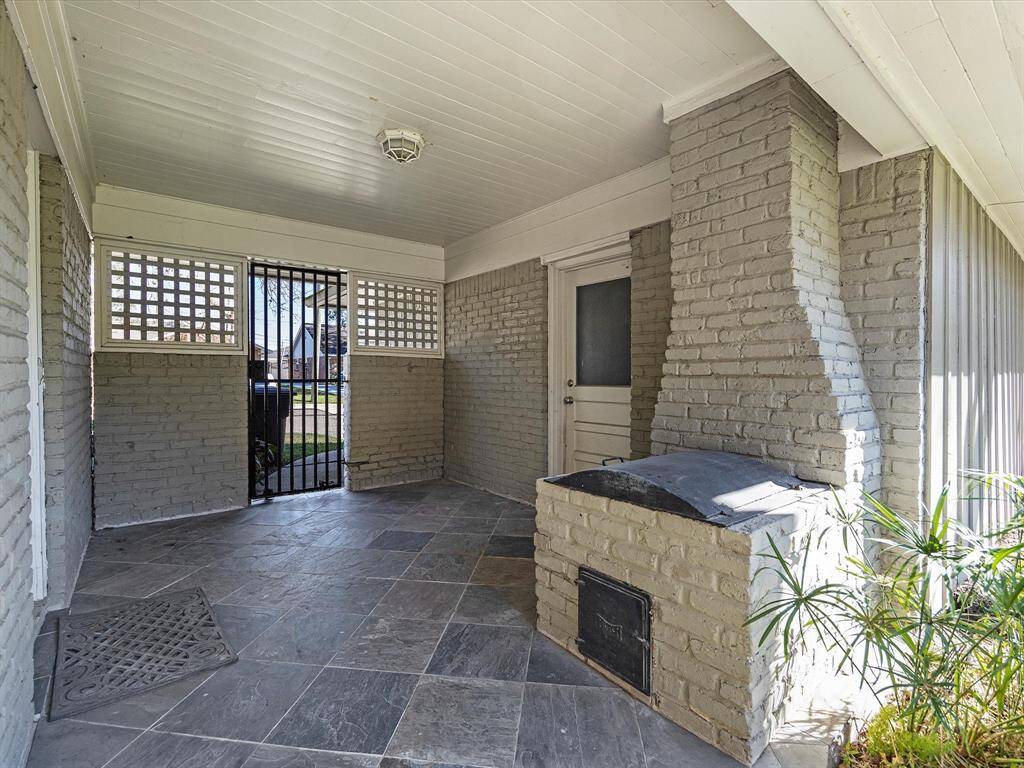 Enjoy outdoor entertaining with a charming brick grill and chimney on the patio.