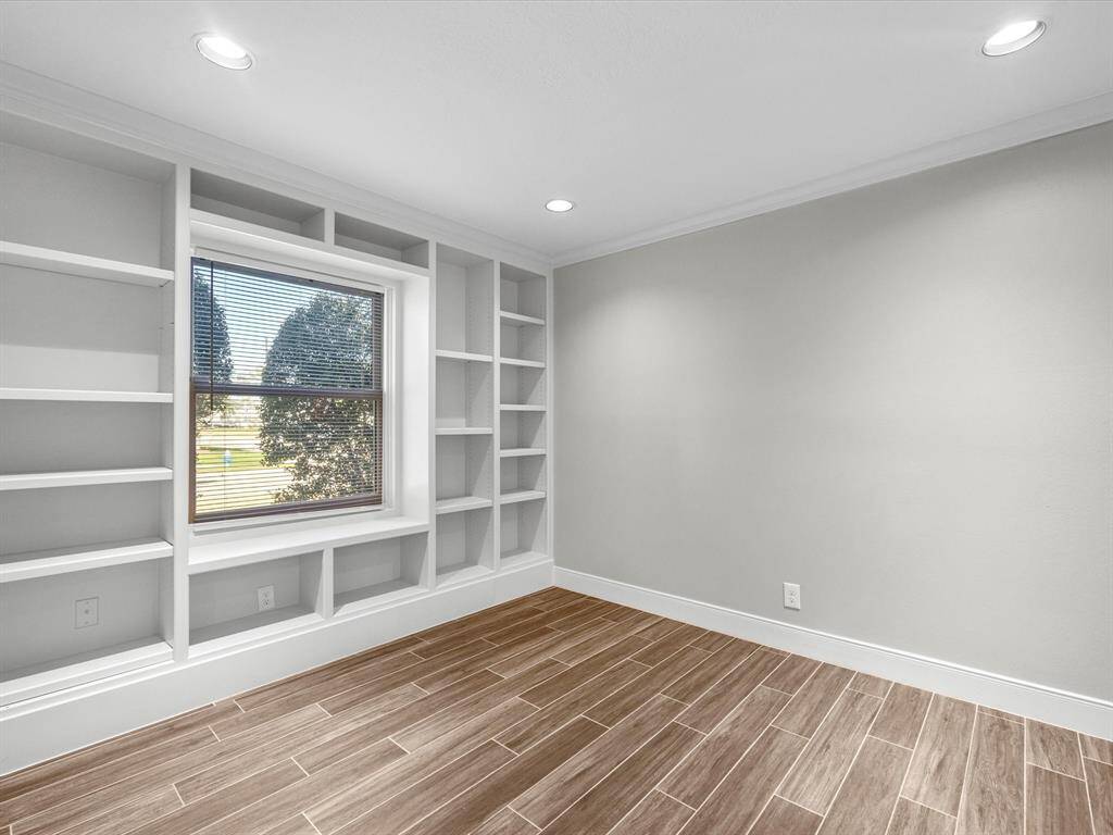 Cozy office with built-in shelving, conveniently located off the dining area.