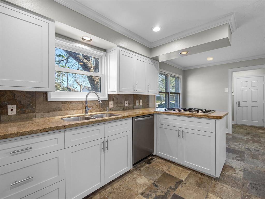 Charming single-story home with a brick exterior, featuring a well-maintained front yard and mature tree. A curved walkway leads to the inviting entrance, surrounded by lush greenery and shrubbery. Ideal for comfortable living in a serene setting.