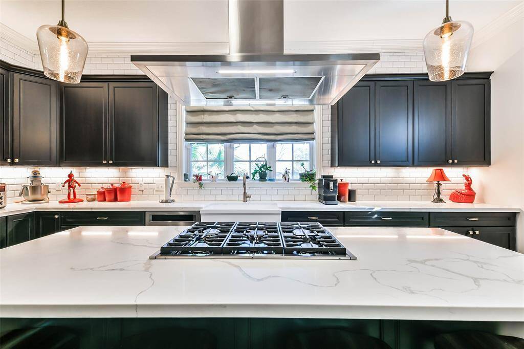 Six burner cooktop in island with quartz countertop