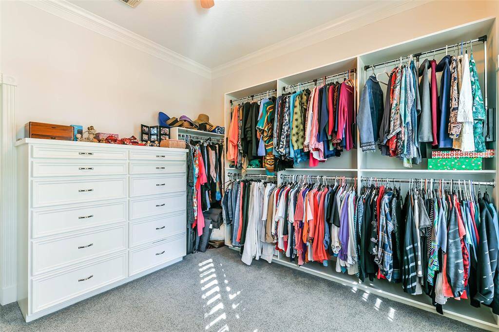 Main house primary walk in closet with built ins and pull down clothing racks