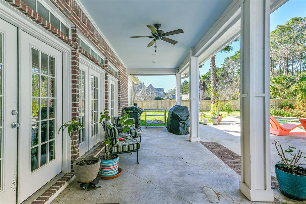 Main house back porch that overlooks backyard and pool