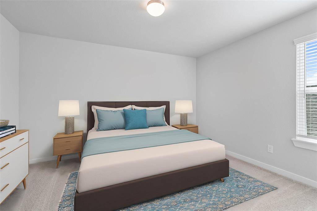 Secondary bedroom features plush carpet, custom paint, lighting, and a large window with privacy blinds.