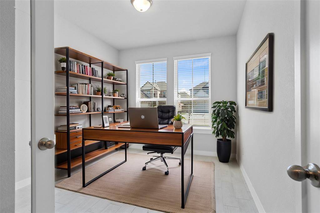 Quietly nestled in front of the home is the handsome home office! Featuring wood look tile flooring, high ceilings, large windows with privacy blinds, and custom paint.