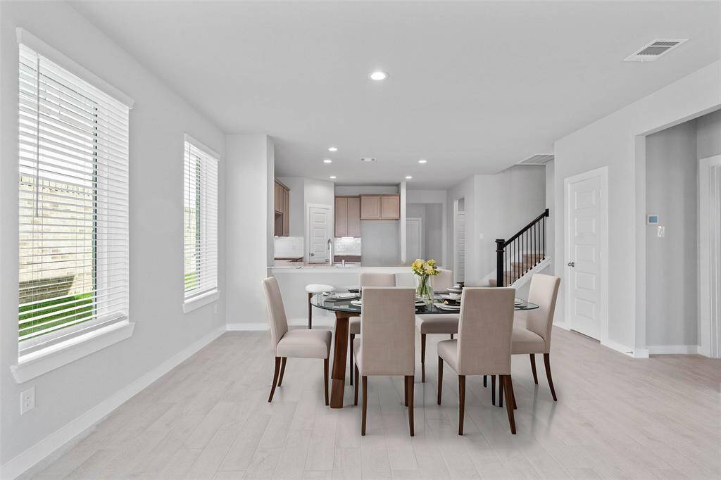 Start your day off right with a cup of coffee sitting with your family in this lovely dining area! Featuring large windows with blinds, custom neutral paint, tile flooring, recessed lighting and high ceilings!