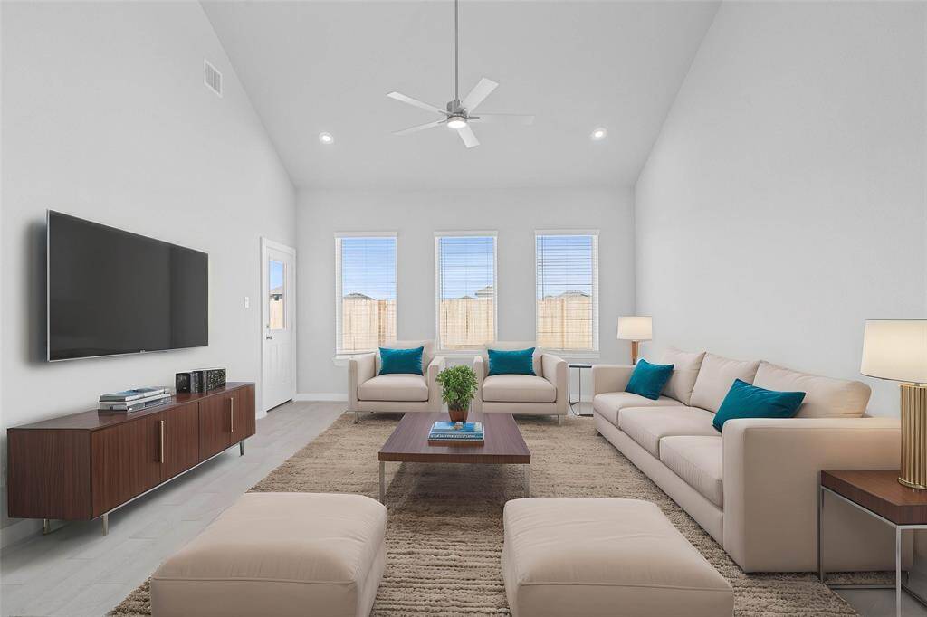 Gather the family and guests together in your lovely family room! Featuring high ceilings, recessed lighting, ceiling fan, custom paint, gorgeous tile floors, and large windows that provide plenty of natural lighting throughout the day.